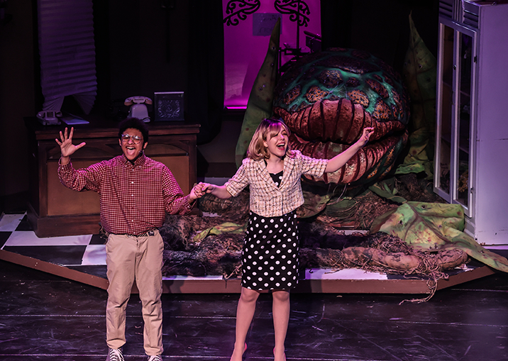 Students on stage during a performance of Little Shop of Horrors