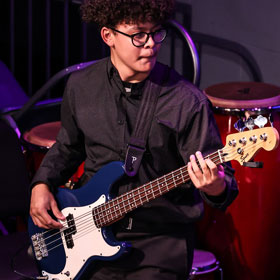 A student playing bass guitar