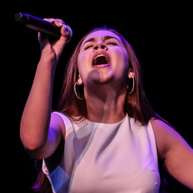 A student belting into a microphone
